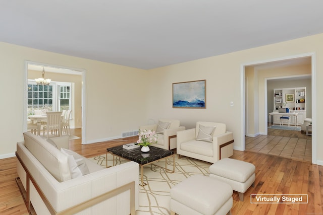 living room featuring a chandelier and light hardwood / wood-style floors