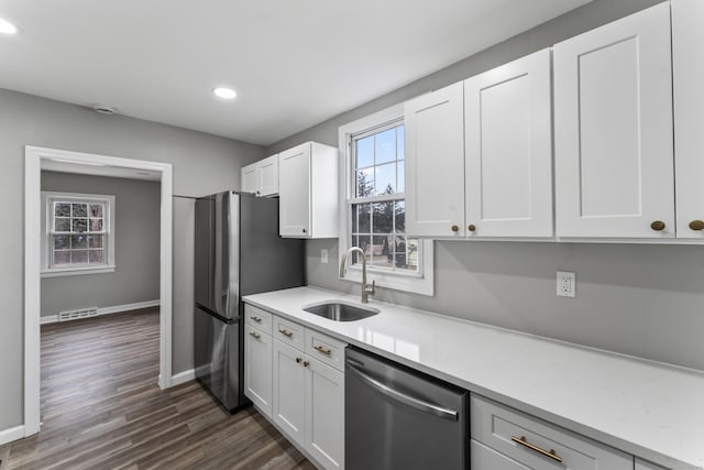 kitchen featuring dark wood-type flooring, sink, white cabinets, and stainless steel appliances