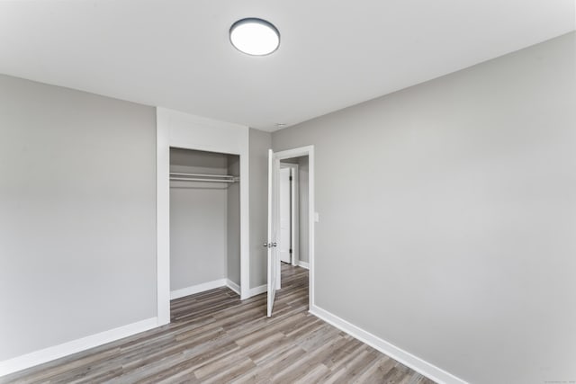 unfurnished bedroom with light hardwood / wood-style floors and a closet