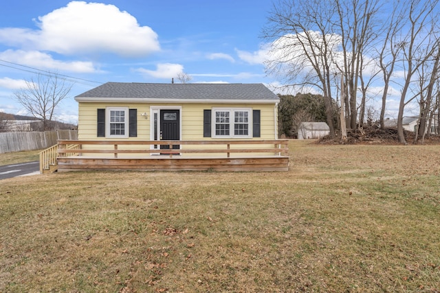 view of front of home with a deck and a front lawn