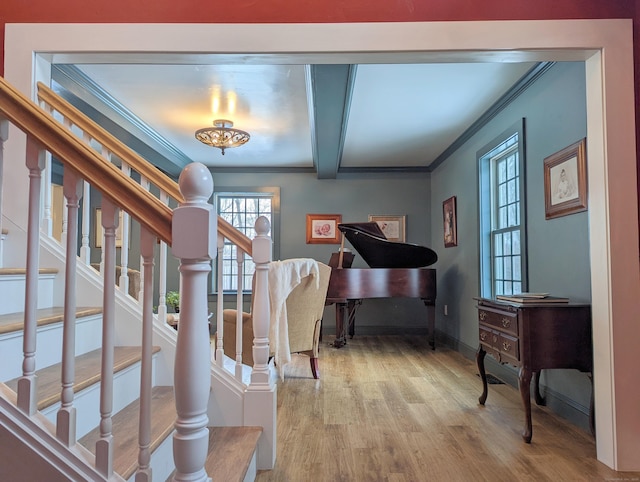 interior space featuring beam ceiling, hardwood / wood-style flooring, and crown molding