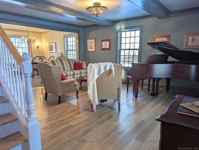 living room with crown molding, wood-type flooring, beamed ceiling, a chandelier, and plenty of natural light