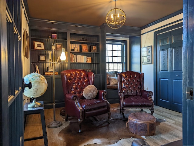 sitting room featuring ornamental molding, a chandelier, and wood-type flooring