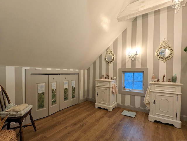 bathroom with wood-type flooring and vaulted ceiling