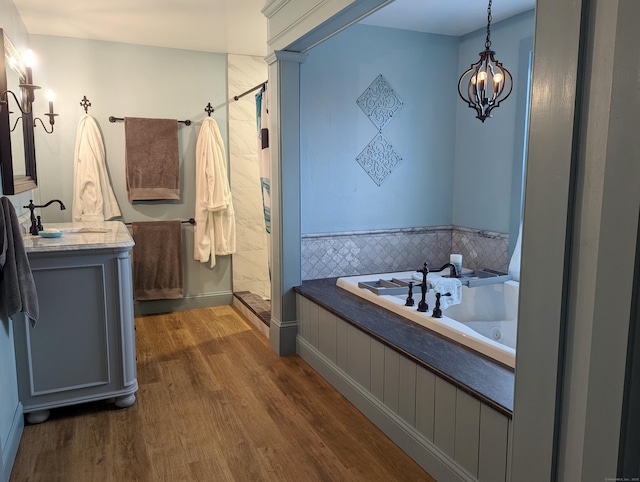 bathroom featuring hardwood / wood-style flooring, a notable chandelier, vanity, and independent shower and bath