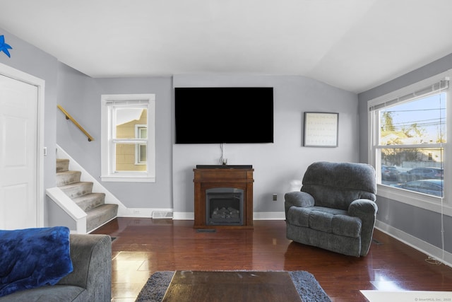 living room with dark wood-type flooring and vaulted ceiling