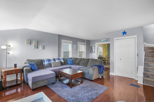 living room with dark wood-type flooring and vaulted ceiling