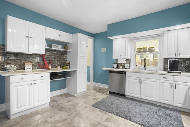 kitchen with decorative backsplash, white cabinetry, sink, and stainless steel dishwasher