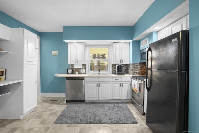 kitchen with white cabinets, appliances with stainless steel finishes, backsplash, and sink