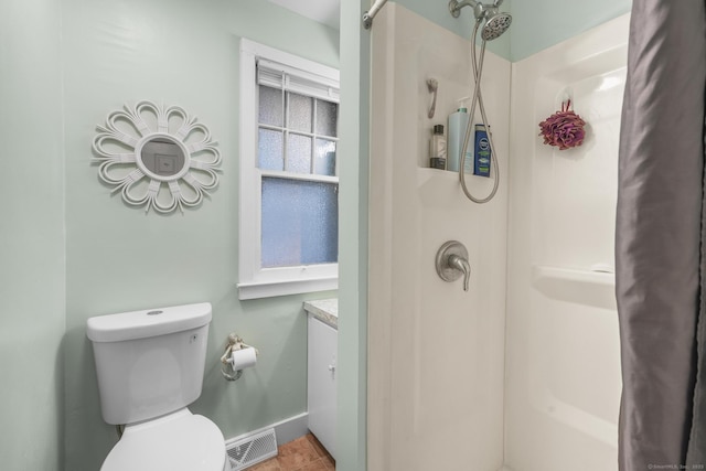 bathroom featuring tile patterned floors, a shower, vanity, and toilet