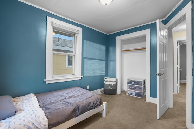 bedroom featuring carpet flooring, crown molding, and a closet