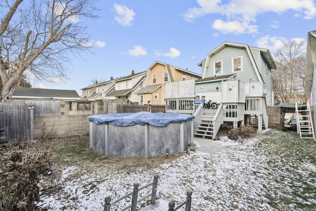 snow covered back of property with a swimming pool side deck