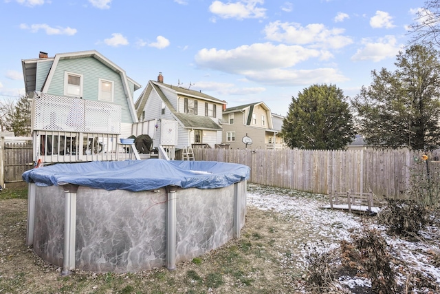 rear view of house with a covered pool