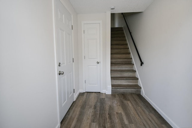 stairway with hardwood / wood-style floors and a textured ceiling