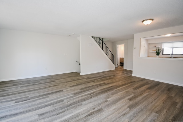 empty room with a textured ceiling, hardwood / wood-style flooring, and sink