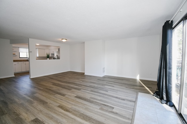 spare room featuring hardwood / wood-style floors and a textured ceiling