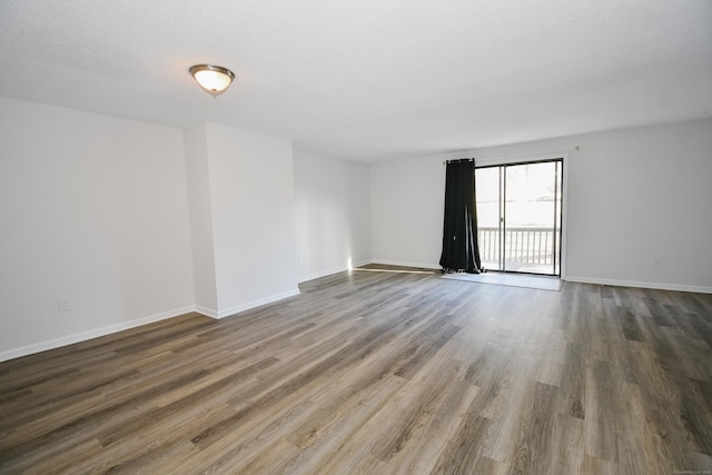 spare room featuring a textured ceiling and hardwood / wood-style flooring