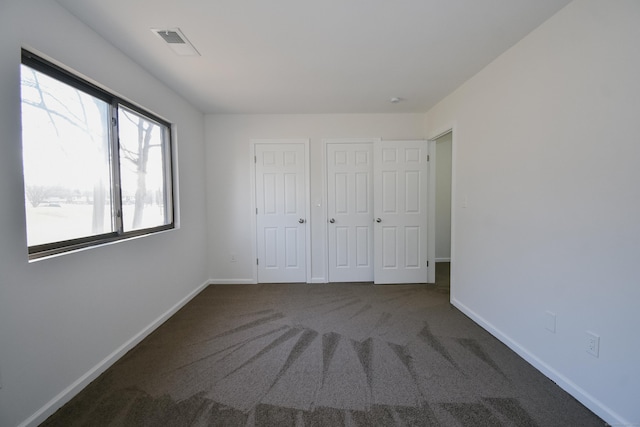 unfurnished bedroom with dark carpet