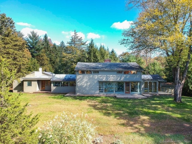 back of property with a patio, a balcony, and a lawn