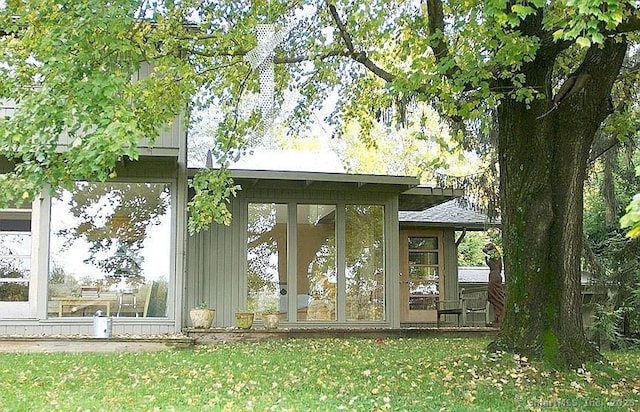 exterior space with a lawn and a sunroom