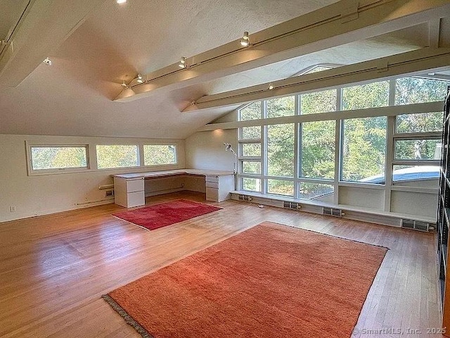 bonus room featuring vaulted ceiling with beams and wood-type flooring