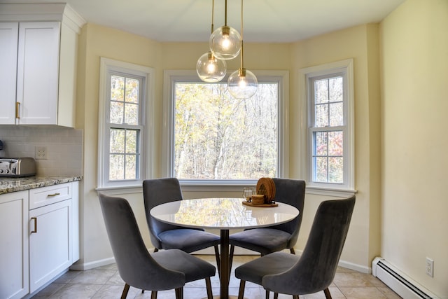 dining area with light tile patterned floors, a baseboard radiator, and baseboards