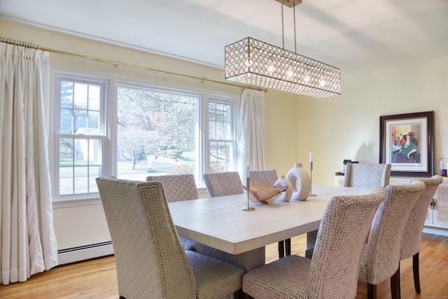 dining room with light wood-style floors and a baseboard heating unit