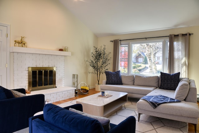 living room with high vaulted ceiling, a fireplace, and wood finished floors