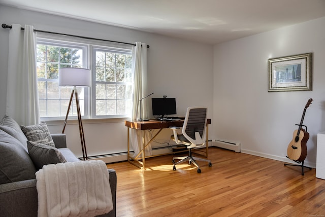 office space with baseboards, light wood-style flooring, and baseboard heating