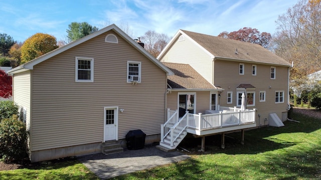 back of property featuring entry steps, a lawn, a chimney, a wooden deck, and a patio area