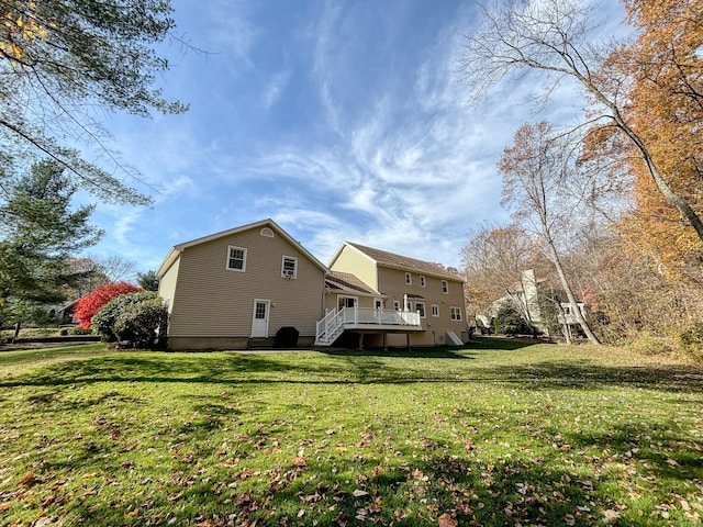 back of property with a lawn and a wooden deck