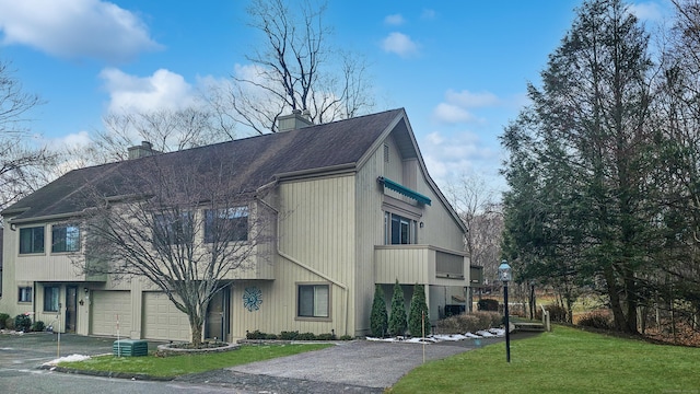 view of side of property featuring a lawn and a garage