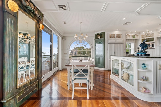 dining space with a chandelier, visible vents, and hardwood / wood-style flooring