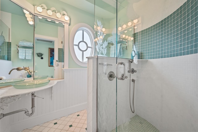 full bathroom with tile patterned floors, a shower stall, and wainscoting