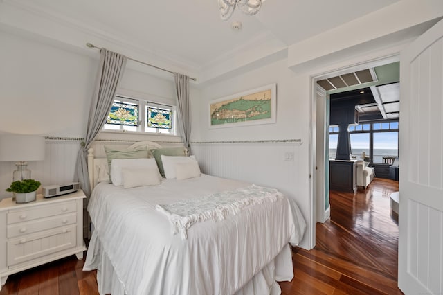 bedroom with dark wood-style floors and multiple windows