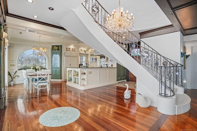 interior space featuring crown molding, recessed lighting, wood-type flooring, visible vents, and a chandelier