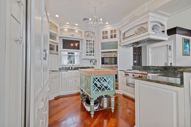 kitchen featuring white cabinets, hardwood / wood-style flooring, butcher block countertops, appliances with stainless steel finishes, and a chandelier