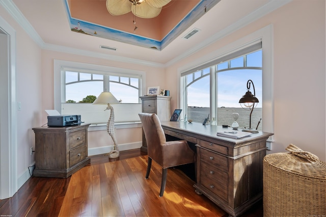 home office with dark wood-style floors, a tray ceiling, visible vents, and ornamental molding