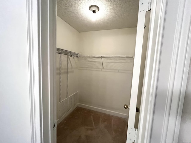 spacious closet with dark colored carpet