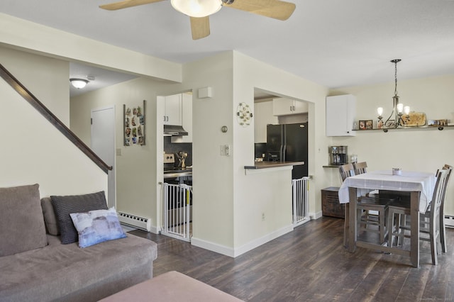 interior space with ceiling fan with notable chandelier, dark wood-type flooring, and a baseboard heating unit