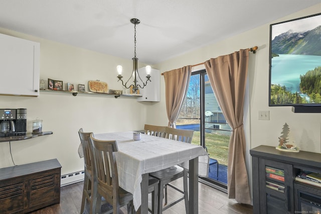 dining room with dark hardwood / wood-style floors, an inviting chandelier, and a baseboard radiator