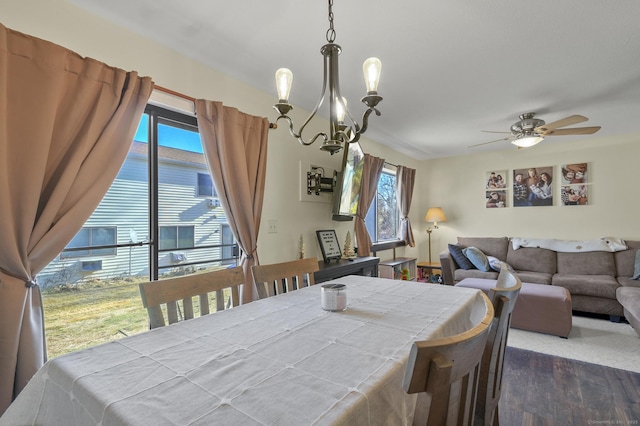 dining room featuring ceiling fan with notable chandelier and dark hardwood / wood-style floors