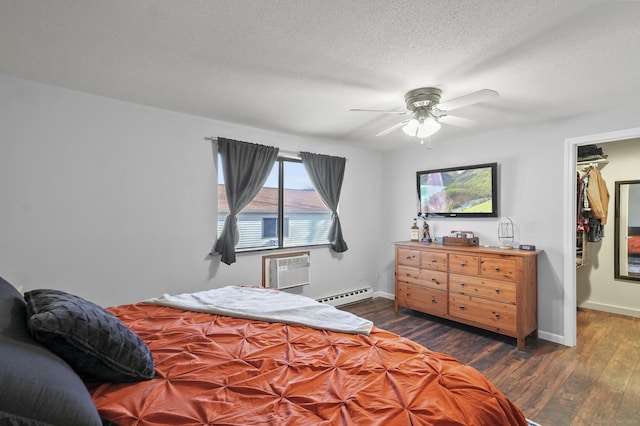 bedroom with a baseboard radiator, a textured ceiling, dark hardwood / wood-style flooring, a wall mounted AC, and ceiling fan