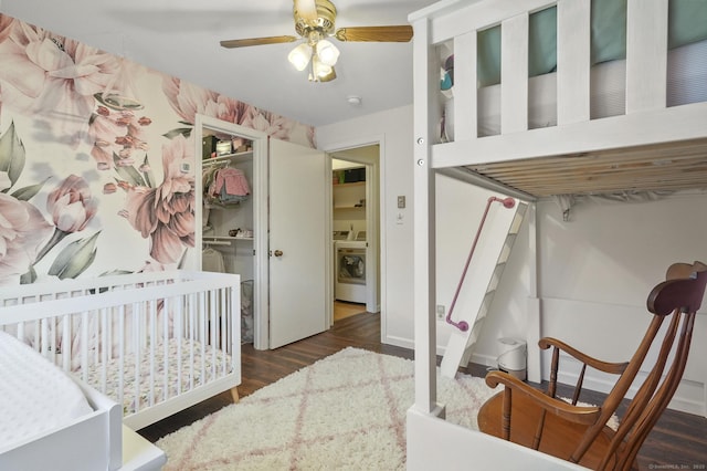 bedroom with washer / clothes dryer, dark hardwood / wood-style floors, a closet, ceiling fan, and a nursery area