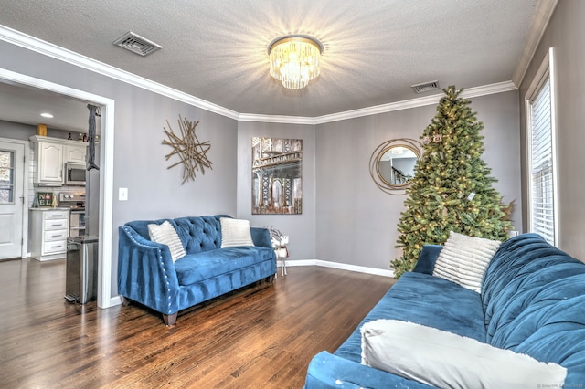 living room with dark hardwood / wood-style floors, ornamental molding, a textured ceiling, and an inviting chandelier