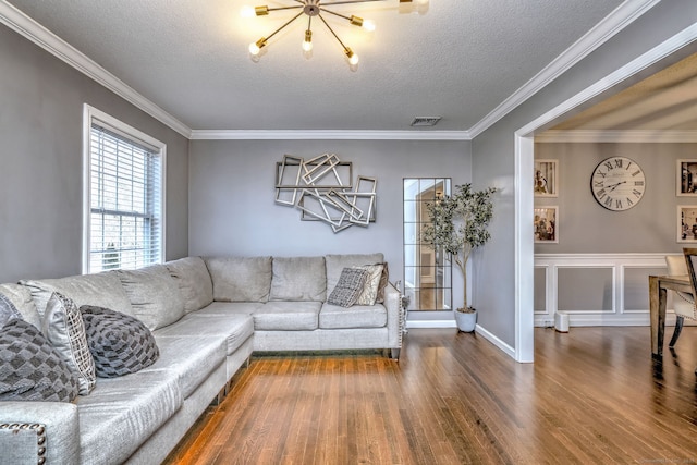 living room featuring crown molding, a chandelier, a textured ceiling, and hardwood / wood-style flooring