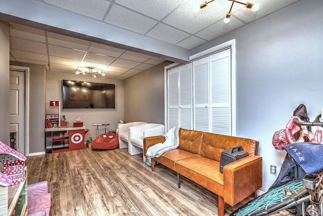 living room with a paneled ceiling and hardwood / wood-style flooring