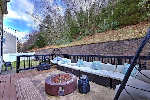 deck featuring an outdoor living space with a fire pit