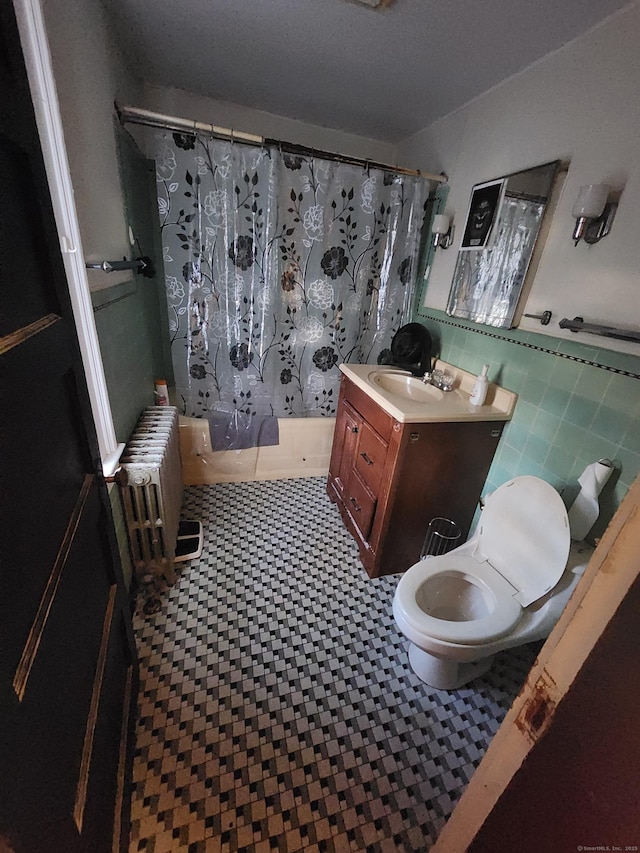 full bathroom with shower / bath combo, toilet, radiator heating unit, and vanity