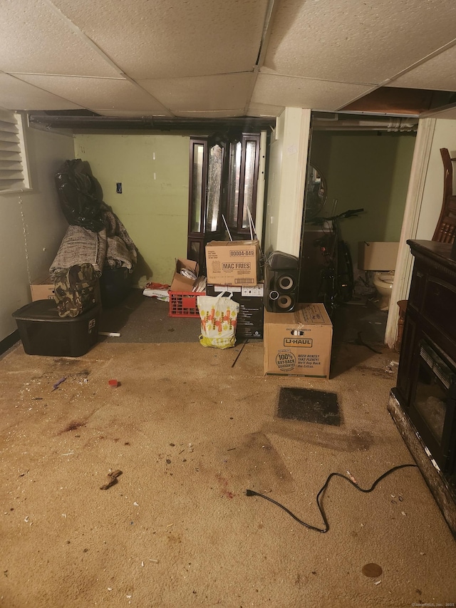 basement featuring carpet flooring and a paneled ceiling